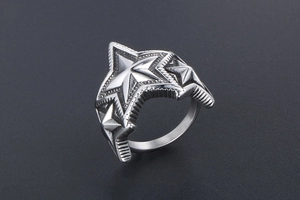 Gros plan d'étoiles pentagrammes superposées sur une bague en acier titane poli