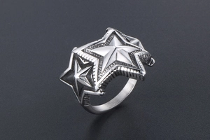 Macro d'une bague punk en acier titane avec étoiles superposées et texture à rayures fines