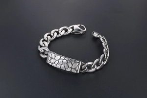 Macro shot of stainless steel cuban chain bracelet featuring pebble texture pattern