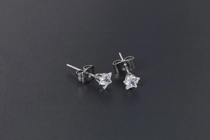 Macro detail of star-shaped titanium steel earrings with sparkling white zircon stones