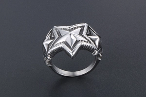 Macro d'une bague punk en acier inoxydable avec motifs d'étoiles 3D et détails texturés