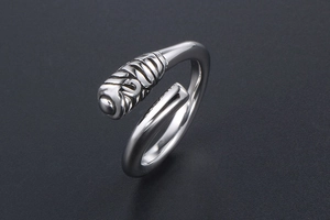 Detail of minimalist titanium steel ring featuring unique relief texture on a gray background