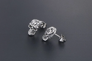 Détail des boucles d'oreilles crâne en acier titane rétro avec finition punk