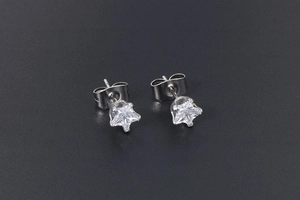Detail of star-shaped titanium steel studs with sparkling clear zircon on black background