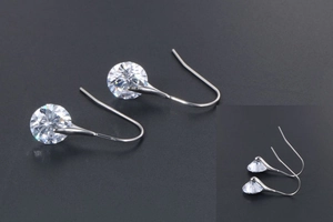 Close-up of sparkling cubic zirconia earrings with classic silver metal hooks for women