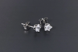 Detailed close-up of mini star-shaped cubic zirconia studs with silver steel finish