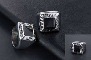 Détail de bague vintage en acier titane avec face carrée noire et motifs de méandres