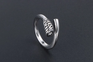 Macro shot of silver titanium steel ring featuring retro spiral engraved detailing