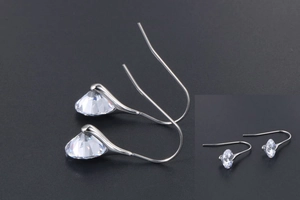 Detail of silver drop earrings featuring large multi-faceted clear cubic zirconia stones