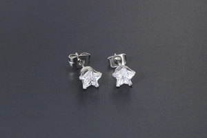 Detailed view of silver star earrings with clear cubic zirconia in five-prong setting