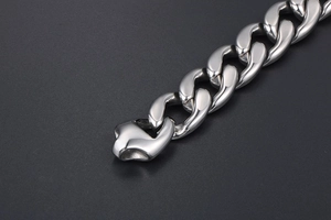 Macro shot of silver polished Cuban link chain bracelet with industrial clasp detail