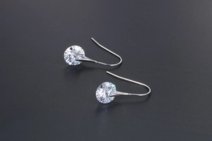 Detailed view of silver hoop earrings with round brilliant-cut sparkling zircons