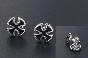 Macro detail of silver titanium cross earrings with black oil drip gothic pattern