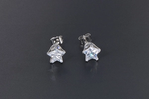 Macro shot of silver star-shaped stud earrings with polished finish and clear zirconia