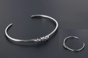Détail macro du décor d'étoiles argentées sur le bracelet jonc vintage en acier