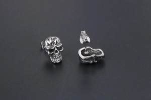 Vue détaillée de boucles d'oreilles crâne vintage avec fermoir papillon et gravure