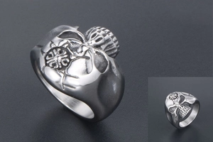 Detailed macro view of vintage stainless steel skull ring with cross emblem and aged finish