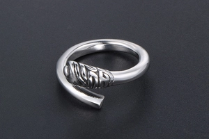 Macro view of adjustable silver titanium steel ring with vintage embossed spiral texture