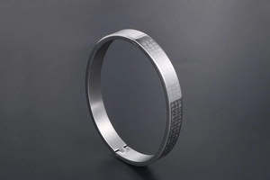 Macro shot of silver stainless steel bangle with engraved Buddhist Heart Sutra scriptures