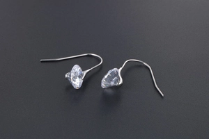 Close-up of sparkling round cut crystal earrings with polished minimalist silver hooks