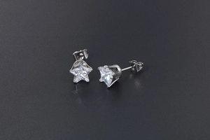 Close-up of titanium steel star stud earrings with clear sparkling zircon stones