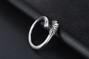 Close-up of silver titanium steel ring featuring twisted rope detail on open band