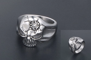 Macro detail of vintage stainless steel skull ring with embossed cross and aged metal finish