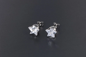 Macro shot of silver star-shaped stud earrings with clear white zircon stones
