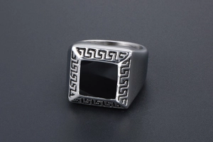 Détail d'une bague chevalière pour homme en argent avec émail noir et motif grec