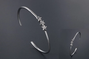 Vue détaillée du bracelet jonc en acier inoxydable argenté avec trois étoiles en relief