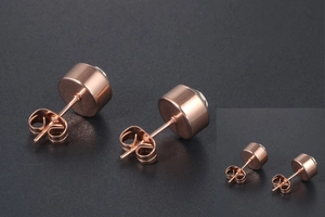Detail of rose gold titanium stud earrings with round zircon and butterfly backings