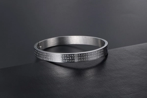 Detail of Heart Sutra engraving on a brushed stainless steel bangle bracelet with side clasp