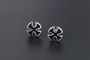 Macro detail of silver titanium cross earrings with black enamel inlay and radial cutout