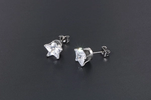 Detailed close-up of a star-shaped stud earring with a clear cubic zirconia stone