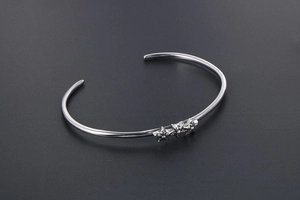 Détail d'un bracelet jonc vintage en acier argenté avec étoiles sur gris