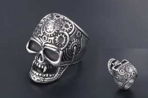 Detailed close-up of a punk style skull ring with intricate gear patterns in vintage silver