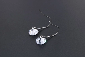 Detailed view of silver hook earrings featuring sparkling round faceted cubic zirconia