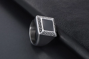 Détail d'une bague chevalière pour homme en titane avec incrustation noire et grecques