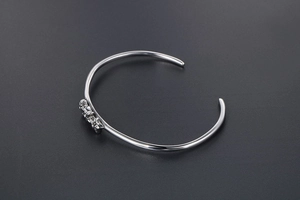 Détail d'un bracelet jonc vintage en acier titane avec des motifs de croix gravés