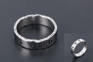 Detailed macro view of men's titanium steel ring with Buddhist mantra and serrated edges