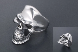 Détail d'une bague tête de mort gothique en acier inoxydable poli avec texture de moulage