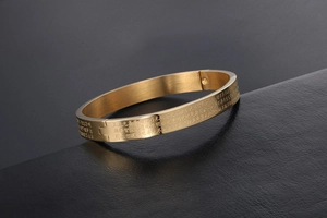 Detail of gold-plated titanium steel cuff featuring engraved Buddhist Heart Sutra