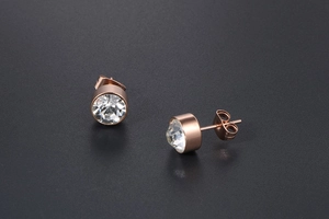 Detailed macro view of rose gold titanium steel stud earrings with clear zircon stones