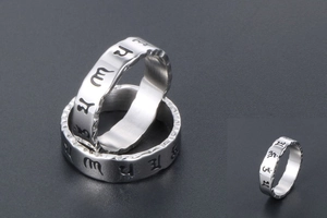 Macro view of men's vintage titanium steel ring with hollow Om Mani Padme Hum engraving
