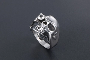Detailed view of skull ring showing vintage finish and intricate metal carvings