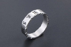Macro detail of men's vintage titanium steel ring with hollowed Sanskrit mantra engraving