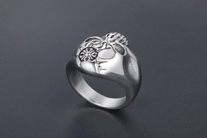 Detail shot of vintage stainless steel biker ring with embossed cross and abstract patterns