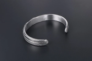 Detailed macro shot of vintage silver eagle feather engraving on stainless steel cuff