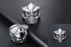 Macro detail of a gothic silver skull ring showing intricate armor textures and deep eye sockets