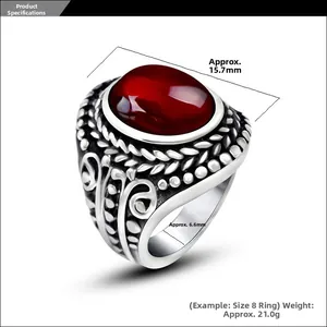 Macro shot of vintage titanium steel ring with red oval gemstone and ornate carvings